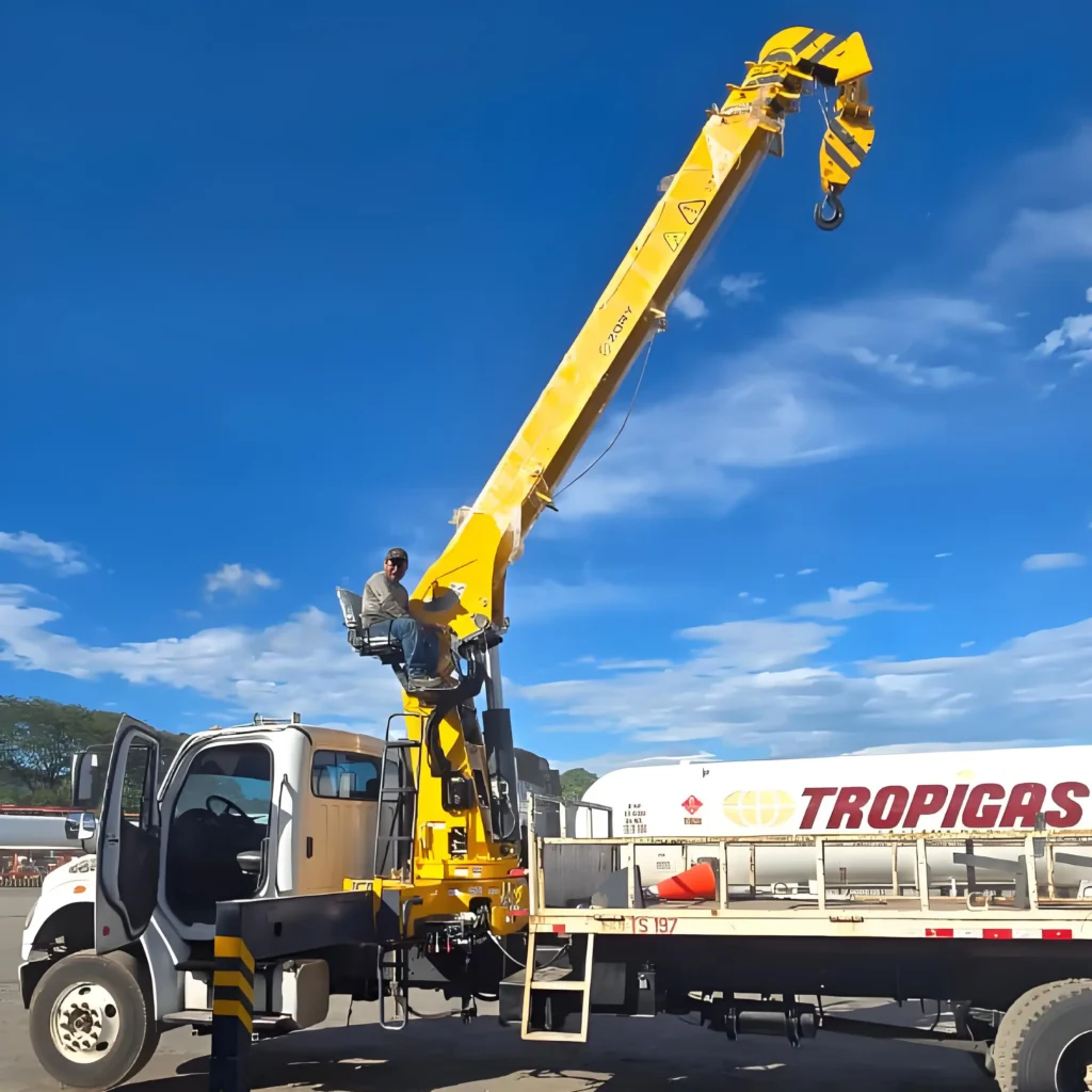 Post-installation testing of a 10 ton telescopic crane (truck mounted crane 10 ton) by a customer. The yellow hydraulic crane, a type of truck mounted crane, is shown with its boom raised on the vehicle.