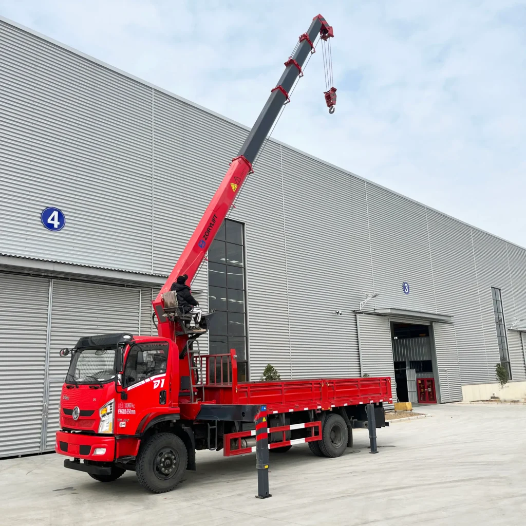 Customer's ZORYLIFT truck mounted telescopic crane installed on a red Dongfeng truck, ready for delivery outside the factory.