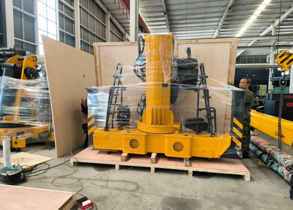 Preparation for export: Workers are packaging the main components of a large 12 ton truck mounted crane[^1] inside the factory, using stretch wrap and wooden crating for reinforcement, readying the heavy-duty crane[^1] for international shipping.