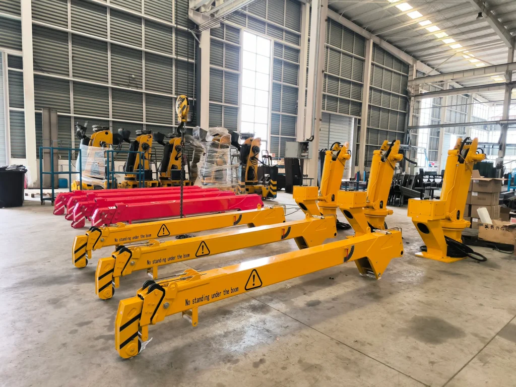 Several small truck mounted cranes, model SQS42A-3 (2 ton telescopic crane), shown in yellow on the production floor.