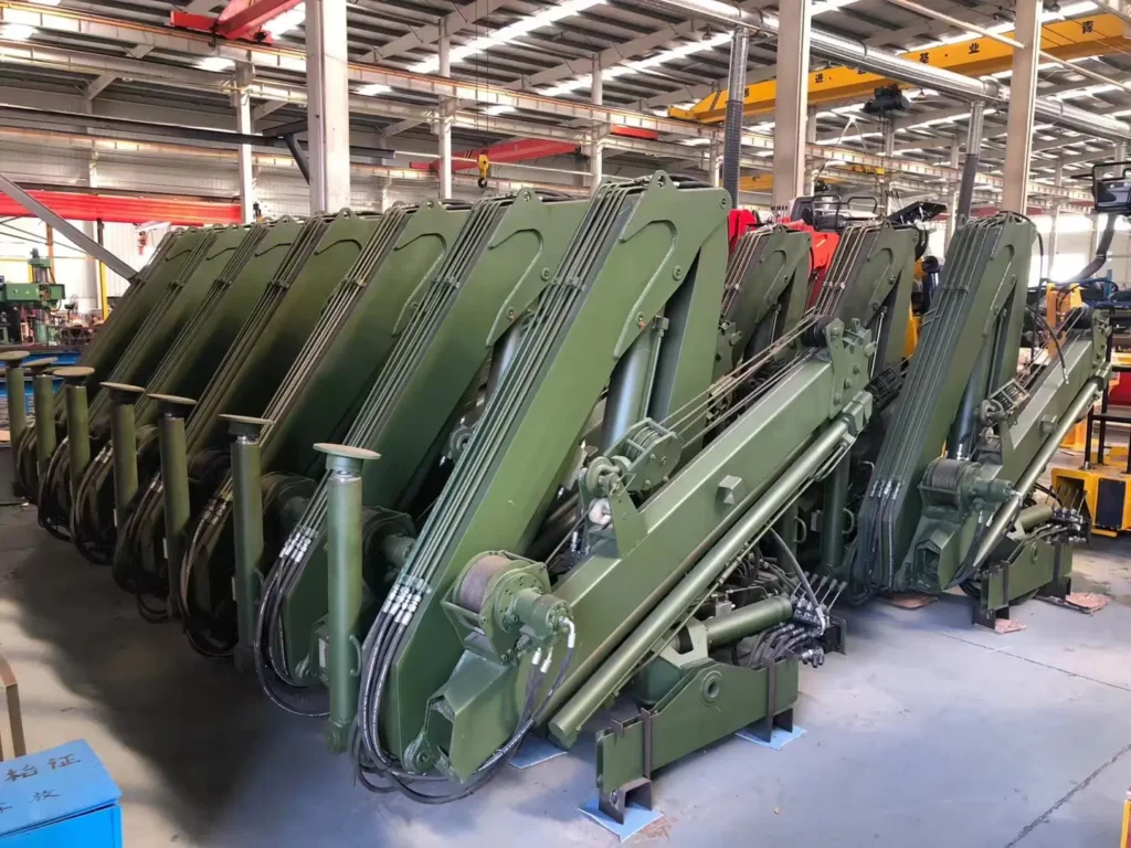 Customer order of SQZ68A.2 folding boom cranes , painted green, shown at the truck mounted crane manufacturers facility.